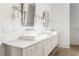 Bright bathroom featuring double sinks, marble backsplash, sconces, and chrome framed mirrors at 248 Madison Ave, Decatur, GA 30030