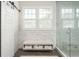 Modern bathroom featuring a glass shower, marble tiling, and a seating area with towel storage at 248 Madison Ave, Decatur, GA 30030