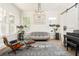 Stylish sitting room showcases a unique grey settee, hardwood floors, and abundant natural light at 248 Madison Ave, Decatur, GA 30030