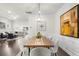 Bright dining area featuring a wooden table, upholstered chairs, stylish chandelier, and open access to living area at 2947 Knob Creek Dr, Snellville, GA 30078