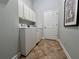 Functional laundry room with appliances, storage cabinets, and tile flooring at 3515 Brandywine Nw Rd, Kennesaw, GA 30144