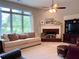 Cozy living room featuring a fireplace, plush seating, and natural light from a large window at 3515 Brandywine Nw Rd, Kennesaw, GA 30144