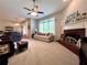 Bright living room with carpet, fireplace, ceiling fan, and views of the dining area at 3515 Brandywine Nw Rd, Kennesaw, GA 30144