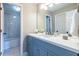 Bright bathroom with blue vanity, white countertop, mirror, and white tiled shower at 883 Heritage Pl, Decatur, GA 30033