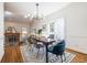 Elegant dining room with modern light fixture, dark wood table, and hardwood floors at 883 Heritage Pl, Decatur, GA 30033