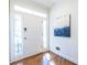 Bright foyer with hardwood floors, white door, sidelights, transom window, and artwork at 883 Heritage Pl, Decatur, GA 30033