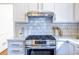 Close-up of a stainless steel gas range with white subway tile backsplash and quartz countertops at 883 Heritage Pl, Decatur, GA 30033