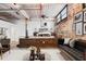 Bright living room with exposed brick and ductwork, raised bedroom area, and modern furniture at 170 Boulevard Se # E003, Atlanta, GA 30312