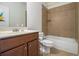 Traditional bathroom with tiled shower/tub, cherry vanity, and neutral tile floors at 218 3Rd Ave, Avondale Estates, GA 30002
