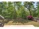 A backyard view showcases natural landscaping, green lawns, and trees at 544 Pine Way, Dallas, GA 30157