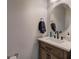 Stylish powder room with a wood vanity, white countertop, and a round mirror at 544 Pine Way, Dallas, GA 30157