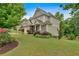 Two-story home with a stone-accented garage, inviting entryway, landscaped front yard, and lush greenery at 544 Pine Way, Dallas, GA 30157