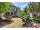 Landscaped front yard with blooming bushes and mature trees surrounding a charming two-story home at 544 Pine Way, Dallas, GA 30157