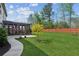 A beautifully manicured backyard with green grass, a small tree, and a screened-in porch at 6435 Privet Way, Cumming, GA 30028