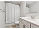 Bright bathroom features a white vanity, neutral tile floor, and shower with curtain at 6435 Privet Way, Cumming, GA 30028