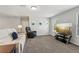 The bonus room features carpet, comfortable seating, a media center, and natural light streaming through the windows at 6435 Privet Way, Cumming, GA 30028