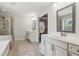 The main bathroom features double sinks, white cabinets, tile flooring, separate shower, and soaking tub at 6435 Privet Way, Cumming, GA 30028