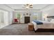 This spacious bedroom offers a tray ceiling, neutral walls, carpet, natural light, and an ensuite bathroom at 6435 Privet Way, Cumming, GA 30028