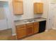 Kitchen featuring light wood cabinets, grey countertops, and black appliances at 6991 Bonnes Blvd, Austell, GA 30168