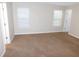 Spacious room with neutral walls, carpeting, and bright natural light from two windows at 6991 Bonnes Blvd, Austell, GA 30168