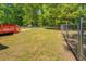 Fenced back yard featuring a wooden deck surrounded by mature trees at 70 Graystone Dr, Covington, GA 30014