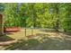 Fenced back yard featuring a small wooden deck and surrounded by mature trees at 70 Graystone Dr, Covington, GA 30014