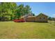An expansive back yard featuring a wooden deck with a sprawling lawn and bordered by mature trees at 70 Graystone Dr, Covington, GA 30014