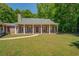 A well-maintained ranch-style home with red shutters, a gray roof, and a covered front porch area surrounded by a green lawn at 70 Graystone Dr, Covington, GA 30014