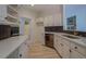 Bright kitchen with white cabinets, stainless steel dishwasher, updated countertops, and a view to the living room at 70 Graystone Dr, Covington, GA 30014