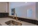 Close-up view of the stainless steel sink and modern faucet with a view to the living room at 70 Graystone Dr, Covington, GA 30014