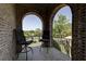 Outdoor balcony featuring seating area, brick archways, and scenic neighborhood views at 8710 Merion Dr, Duluth, GA 30097