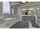Bathroom with a freestanding tub, large windows, and gray cabinetry at 8710 Merion Dr, Duluth, GA 30097