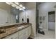 Bathroom featuring a marble countertop, a large mirror, and a shower at 8710 Merion Dr, Duluth, GA 30097