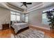 Bright bedroom featuring hardwood floors, tray ceilings, ceiling fan, and natural light at 8710 Merion Dr, Duluth, GA 30097