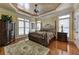 Spacious bedroom with a decorative ceiling, gleaming hardwood floors, and a large four-poster bed at 8710 Merion Dr, Duluth, GA 30097