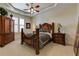 Comfortable bedroom with soft carpeting, a tray ceiling, and a well-placed ceiling fan at 8710 Merion Dr, Duluth, GA 30097