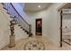 Elegant foyer with decorative tile floor, curved staircase, and view into a wine cellar at 8710 Merion Dr, Duluth, GA 30097