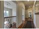 Hallway featuring hardwood floors, a decorative rug, and iron railing at 8710 Merion Dr, Duluth, GA 30097