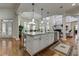 Open concept kitchen with a large center island with granite countertops, stainless appliances, and white cabinetry at 8710 Merion Dr, Duluth, GA 30097