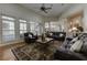 Open living room with stone fireplace, custom bar area, hardwood floors, and plush leather seating at 8710 Merion Dr, Duluth, GA 30097