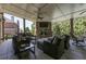 Covered patio with a stone fireplace, comfortable seating, and an outdoor ceiling fan at 8710 Merion Dr, Duluth, GA 30097