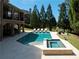 Backyard pool and spa, adjacent to a covered patio, surrounded by lush greenery at 8710 Merion Dr, Duluth, GA 30097