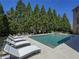 Backyard swimming pool with lounge chairs and mature trees in a private setting at 8710 Merion Dr, Duluth, GA 30097