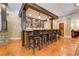 Stylish wet bar with custom cabinets, stone accents, pendant lighting, and seating for several guests at 8710 Merion Dr, Duluth, GA 30097