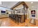 Entertain in style with this wet bar featuring wood accents, barstool seating, and glass shelving at 8710 Merion Dr, Duluth, GA 30097