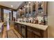 Well-appointed wet bar featuring glass-front cabinets, stone countertops, and a beverage cooler at 8710 Merion Dr, Duluth, GA 30097