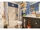 Well-organized bathroom featuring a stylish vanity, tub with shower, and decorative shelves at 1699 Boulder Walk Se Dr, Atlanta, GA 30316