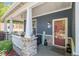 Covered front porch with stacked stone accents, decor, and access to the front entry door at 1699 Boulder Walk Se Dr, Atlanta, GA 30316