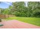 Lush backyard featuring a wooden deck, green grass, and a wood fence, great for pets to run around at 433 Orchid Ln, Canton, GA 30114