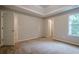 Spacious bedroom featuring plush carpet, a tray ceiling, closet, and ample natural light, perfect for relaxation at 433 Orchid Ln, Canton, GA 30114